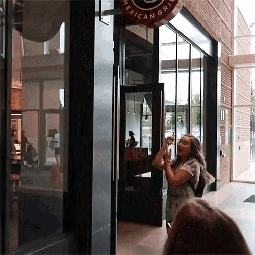 a woman stands outside of a mexican grill restaurant