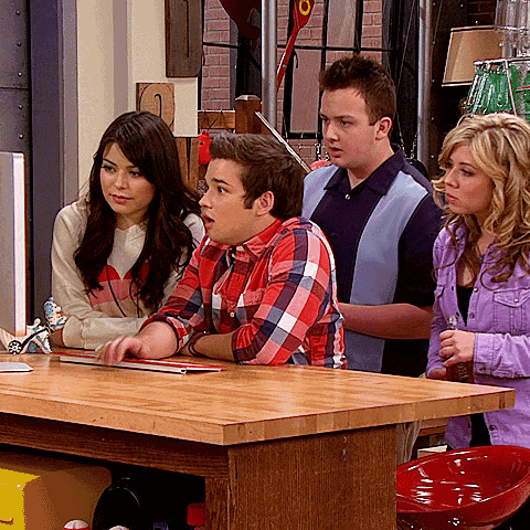a group of people sitting around a table looking at something