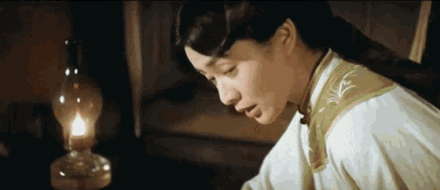 a woman is sitting in front of a lamp in a room .