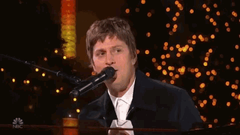 a man singing into a microphone with the name rob thomas written below him