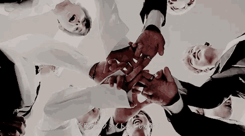 a group of people are holding hands in a circle and making a heart with their hands .
