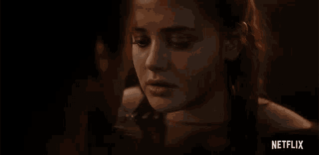 a close up of a woman 's face with a netflix logo in the background .
