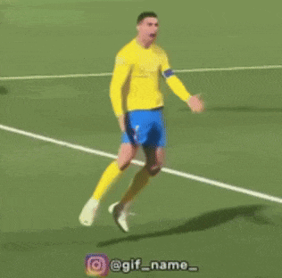 a man in a yellow shirt and blue shorts kicks a soccer ball on a field