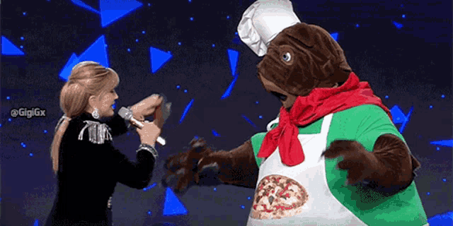 a woman in a chef costume is holding a microphone next to a pizza mascot