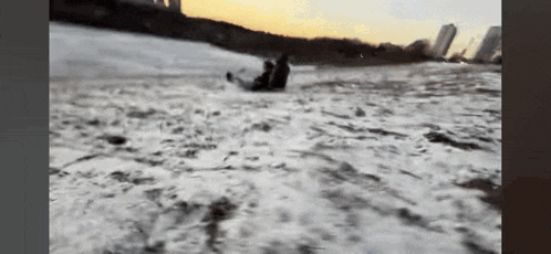a person is sledding down a snow covered hill .