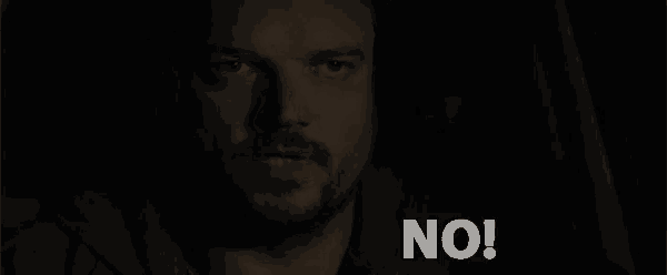 a man with a beard is saying " no " in a dark room