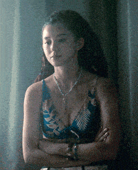 a woman with dreadlocks is wearing a necklace and a bikini top