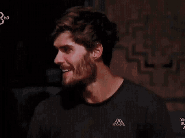 a man with a beard is wearing a kappa shirt