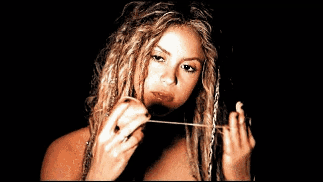 a woman with dreadlocks has the word somosshakifans on the bottom right