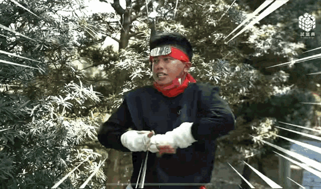 a man with a red bandana on his head is holding a knife