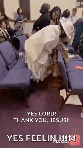 a group of people are sitting in chairs in a church and a woman is kneeling on a chair .