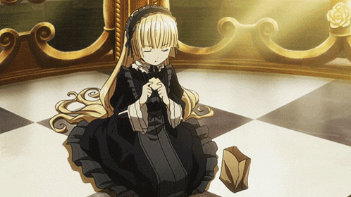 a girl in a black dress sits on the floor praying