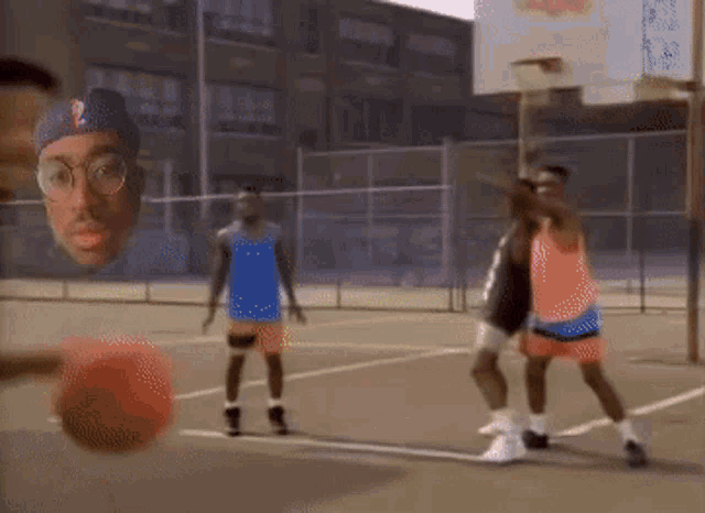 a group of men are playing basketball on a court and one of them is wearing glasses .