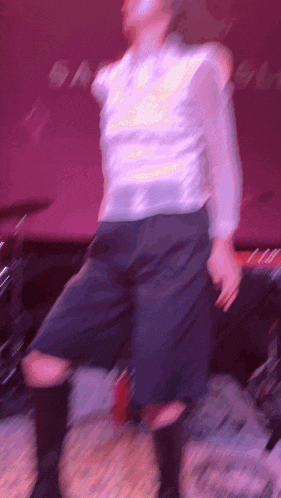 a blurry picture of a person dancing in front of a pink background
