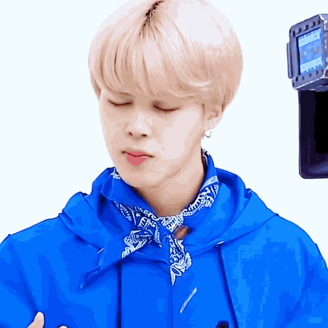 a close up of a person wearing a blue jacket and a bandana