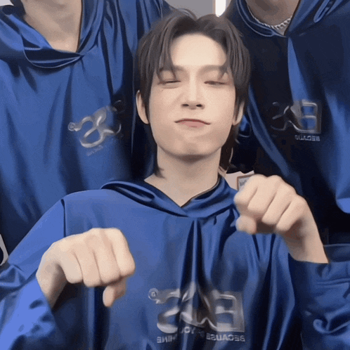 a man wearing a blue hoodie with the letter e on the front