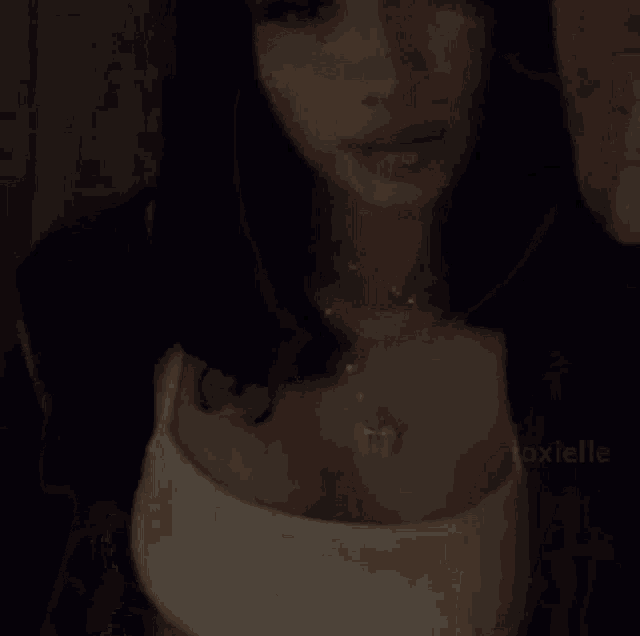 a woman 's belly is shown with a white top and a necklace