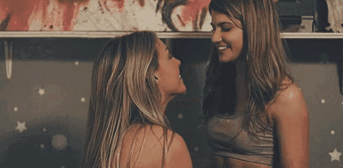 two women are standing next to each other and smiling .