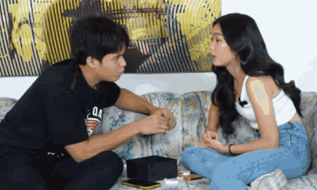 a man and a woman are sitting on a couch and the man has a shirt that says oa on it