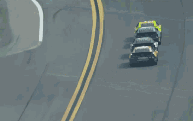 a group of race cars are racing on a track and one of them has the word ford on the side