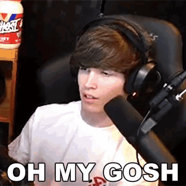 a young man wearing headphones and a white shirt says oh my gosh