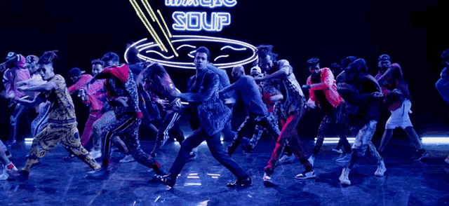 a group of people are dancing in front of a neon sign that says magic soup