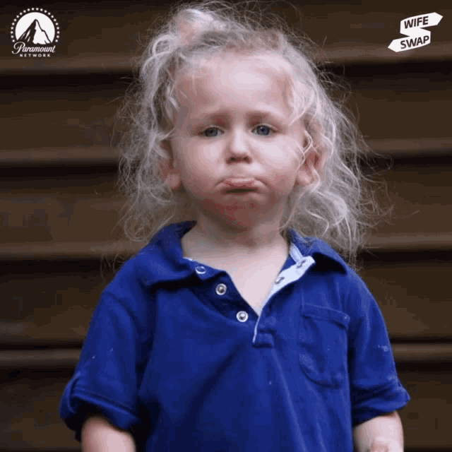 a little girl in a blue shirt with a paramount network logo on the bottom