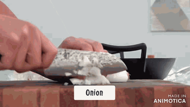 a person is chopping an onion on a cutting board made by animatica