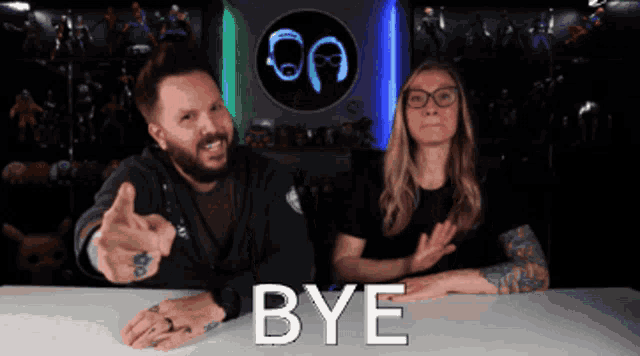 a man and a woman are sitting at a table with the word bye written in white