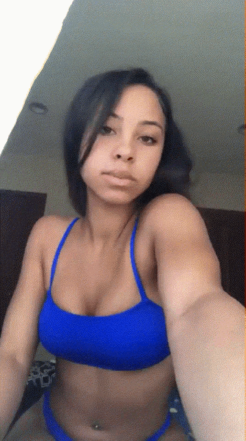 a woman in a blue bikini top taking a selfie