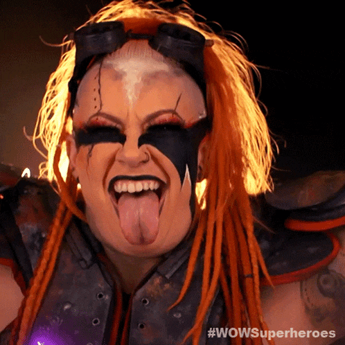 a woman with red dreadlocks sticking her tongue out and the words wowsuperheroes behind her
