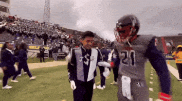 a football player with the number 21 on his jersey is hugging another player
