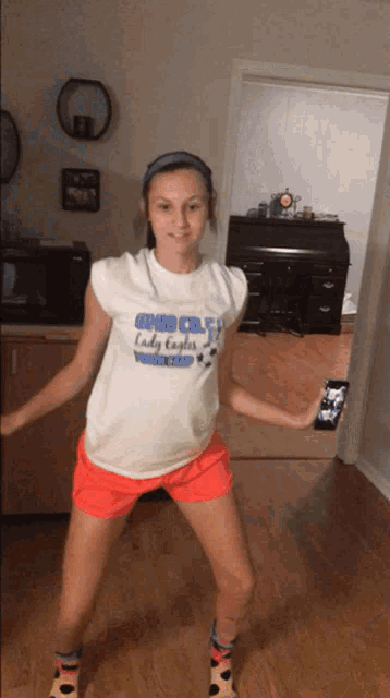 a girl wearing a t-shirt that says lady eagles soccer is dancing