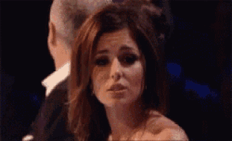 a woman is making a funny face in front of a man .