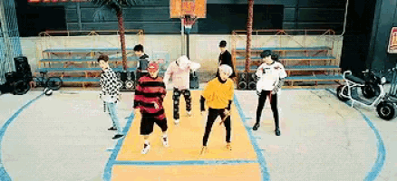 a group of young people are standing on a basketball court .