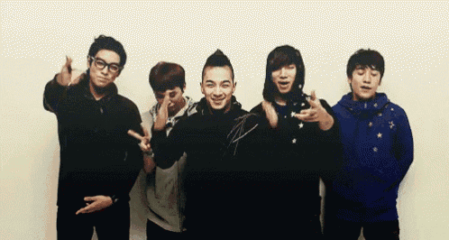 a group of young men are posing for a picture and one is wearing a blue jacket