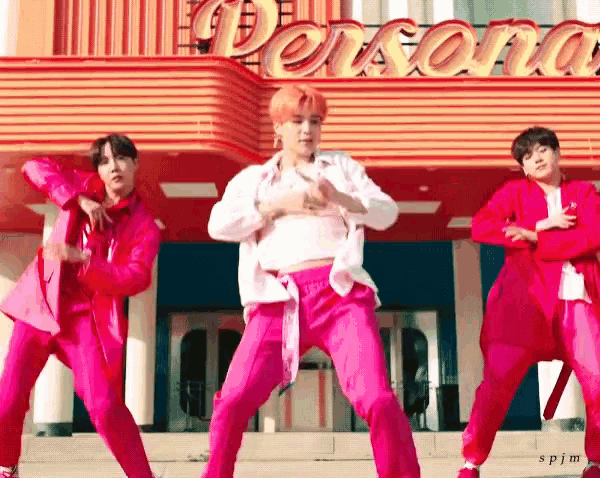 a group of young men are dancing in front of a building that says persona