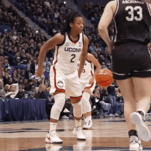 a uconn basketball player is dribbling the ball