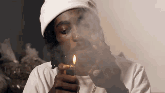 a man in a white hat is smoking a cigarette