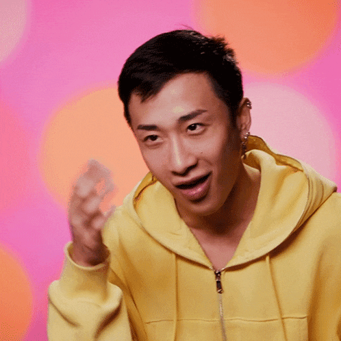 a man wearing a yellow hoodie is making a face