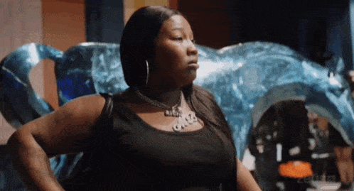 a woman wearing a black tank top and a necklace that says jada
