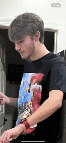 a man wearing a t-shirt with a picture of shanks on it looks at his watch