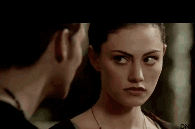 a man and a woman are looking at each other with a serious look on their faces .