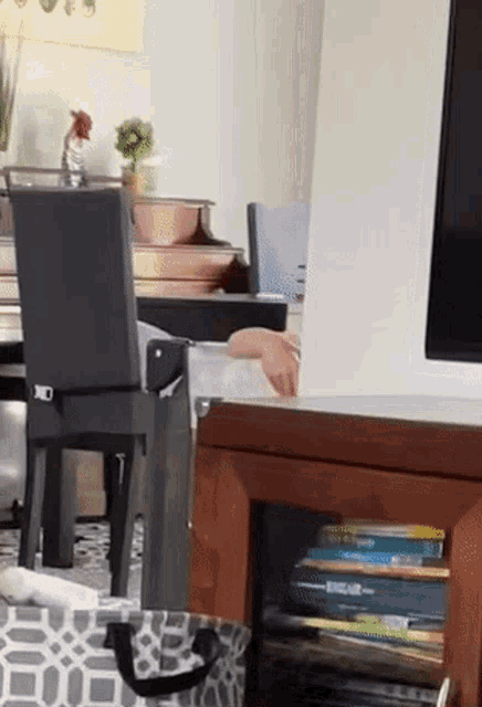 a stack of books sits on a shelf next to a piano
