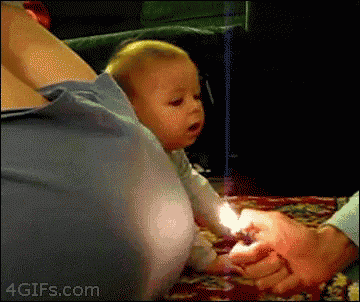 a baby is being held by a person who is holding a lit lighter