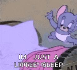 a cartoon character is sleeping in a bed with a pink blanket on .