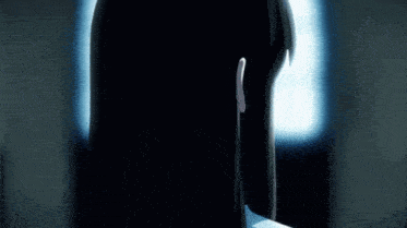 a girl with long black hair is standing in front of a window looking out .