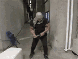 a man is standing in a hallway holding a sword in his hands .