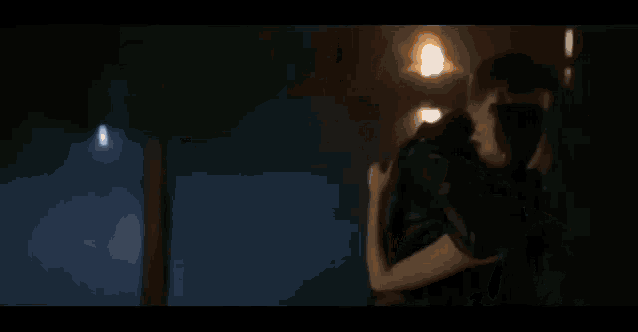 a man and a woman are hugging each other in a room .