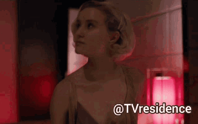 a woman in a red room with the words @tvresidence written below her